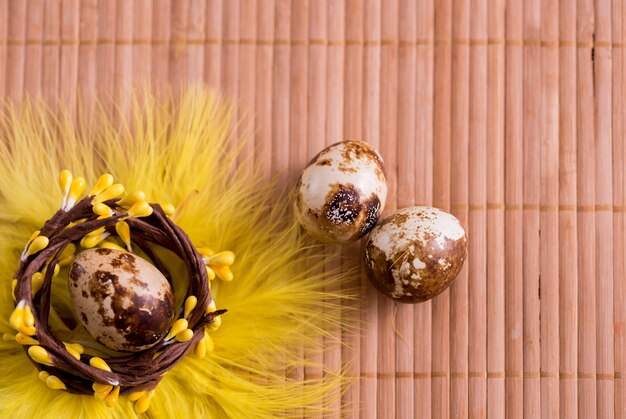 Huevos de Pascua en nido sobre fondo de madera color