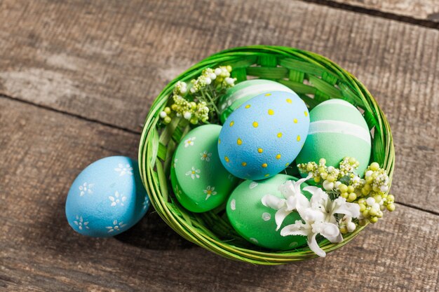 Huevos de Pascua en el nido sobre fondo de madera de color