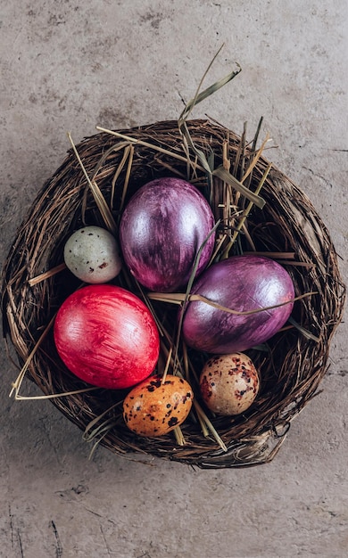 Huevos de Pascua en un nido sobre un fondo de piedraVista superior con una copia del lugar para el texto