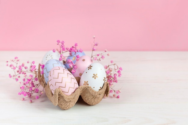 Huevos de pascua en un nido sobre un fondo rosa