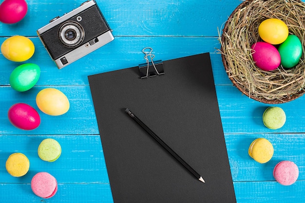 Huevos de pascua en nido sobre tablones de madera rústicos azules