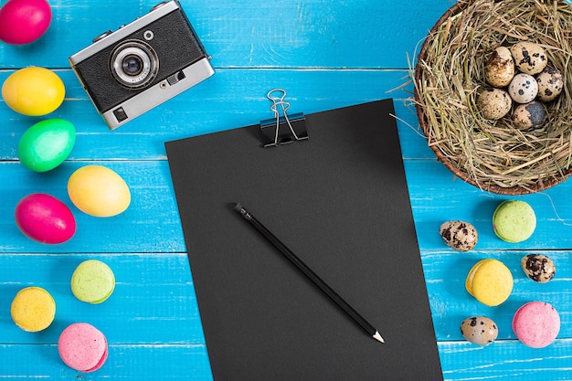 Huevos de pascua en nido sobre tablones de madera rústicos azules