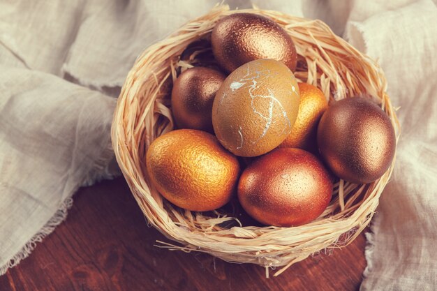 Huevos de Pascua oro en mesa de madera