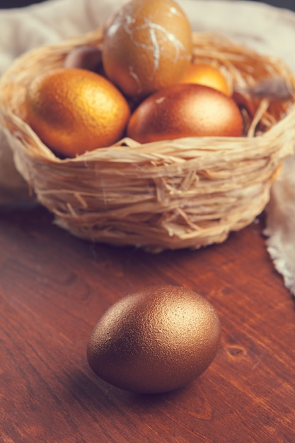 Huevos de Pascua oro en mesa de madera