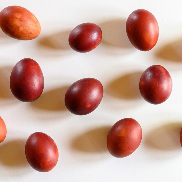 Huevos de Pascua pintados de cáscaras de cebolla sobre un fondo blanco.