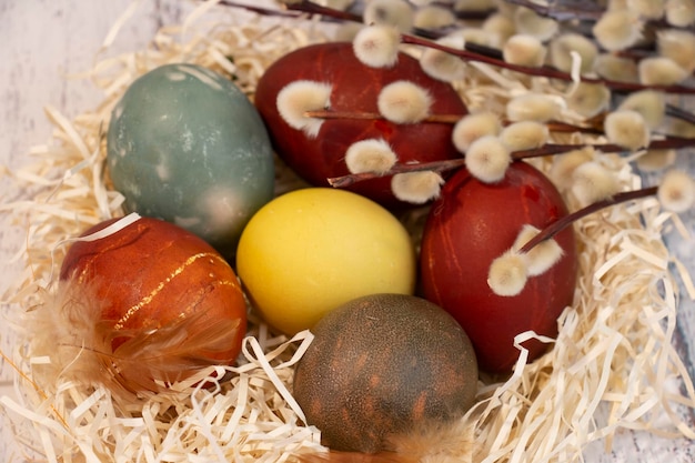 Huevos de Pascua pintados de colores sobre la mesa en un mini nido Simal de Pascua