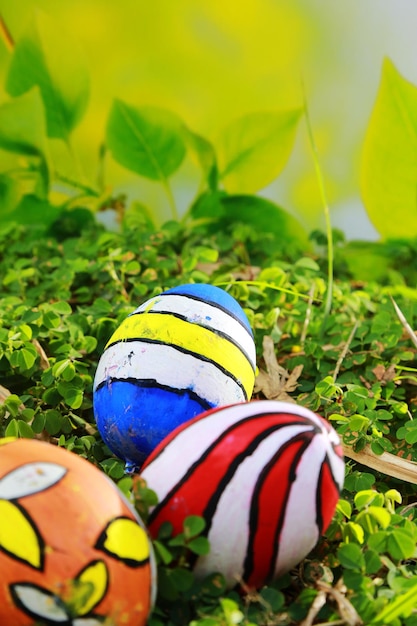 Huevos de Pascua pintados en la hierba con un fondo verde borroso