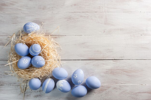 Huevos de Pascua pintados en mesa rústica de madera