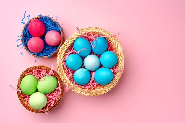 Huevos de Pascua pintados en nido decorativo en rosa cerrar