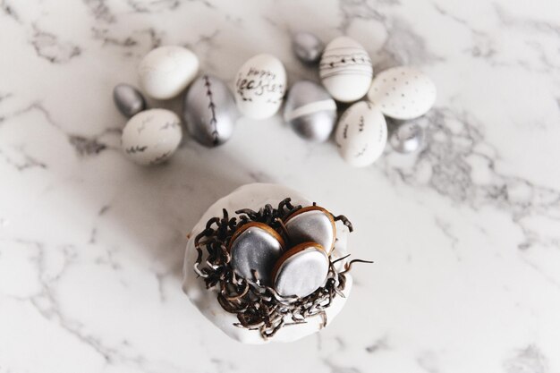 Huevos de Pascua pintados de plata y blancos sobre un fondo claro y espacio libre de postal de pastel para enfoque selectivo de texto