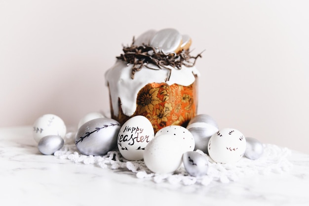 Huevos de Pascua pintados de plata y blancos sobre un fondo claro y espacio libre de postal de pastel para enfoque selectivo de texto