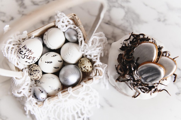 Huevos de Pascua pintados de plata y blancos sobre un fondo claro y espacio libre de postal de pastel para enfoque selectivo de texto