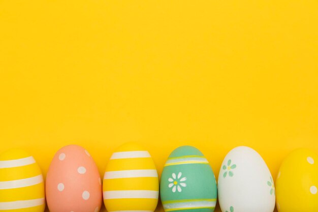 Huevos de pascua pintados sobre un fondo amarillo brillante