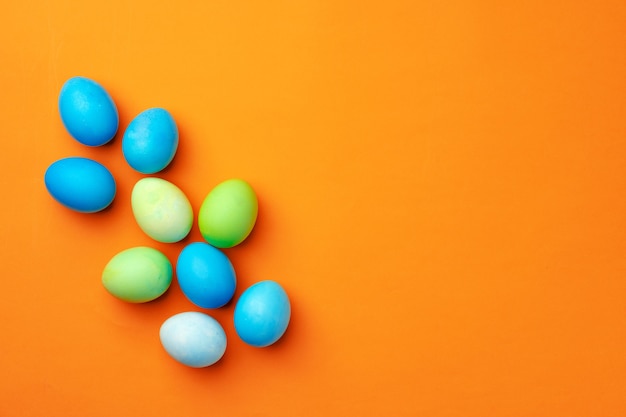 Huevos de Pascua pintados sobre fondo naranja vista superior