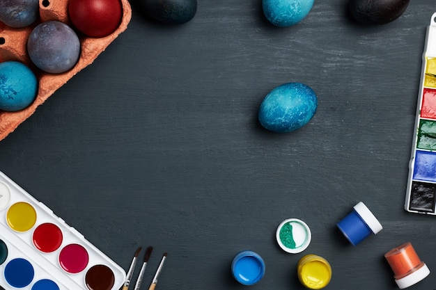 Huevos de Pascua. Pinturas y pinceles para colorear huevos para vacaciones. Vista superior de huevos de Pascua pintados.