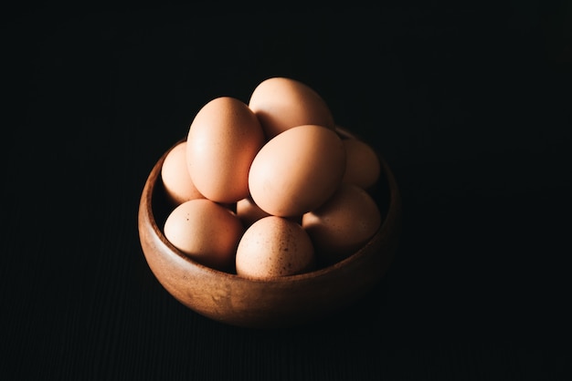 Huevos de Pascua en placa de madera sobre superficie negra. comida rústica, rural, natural y saludable