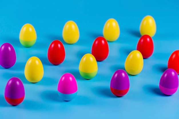 Huevos de Pascua de plástico de colores sobre fondo azul.