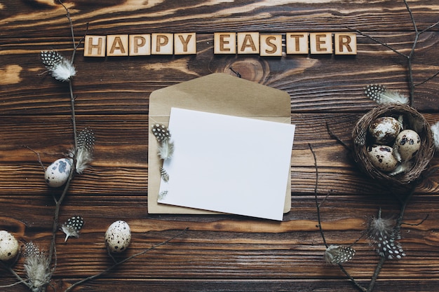 Huevos de Pascua y plumas en el nido y la letra de su texto sobre fondo de madera.