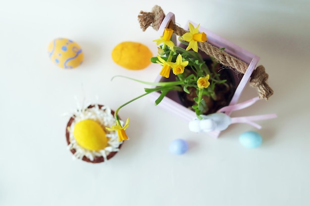 Huevos de pascua, primavera, plantas, liebres de juguete, sobre un fondo claro, decoración interior del hogar