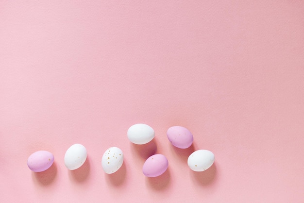 Huevos de pascua rosados y blancos sobre un fondo rosa