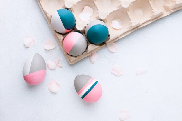Huevos de Pascua rústicos. Bodegón de hermosos huevos de Pascua pintados en mesa blanca. Concepto de individualidad, ser diferente, orgánico, tatuaje en huevo.