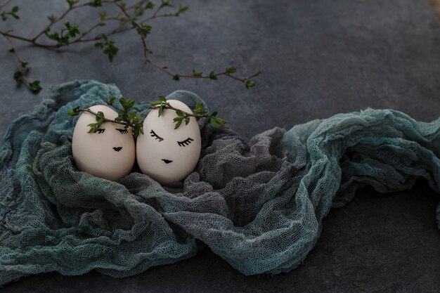 Huevos de Pascua sobre fondo gris. Ramita de vegetación.