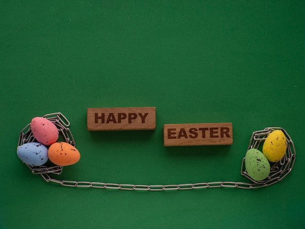 Huevos de Pascua sobre fondo verde con cadena de metal