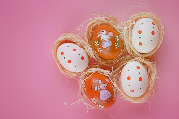 Huevos de Pascua en una superficie rosa