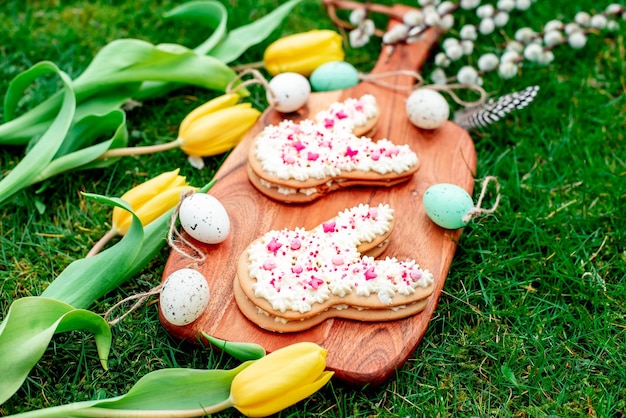 Huevos de pascua en una tabla de madera con un tulipán amarillo y una cuchara de madera con la palabra pascua.