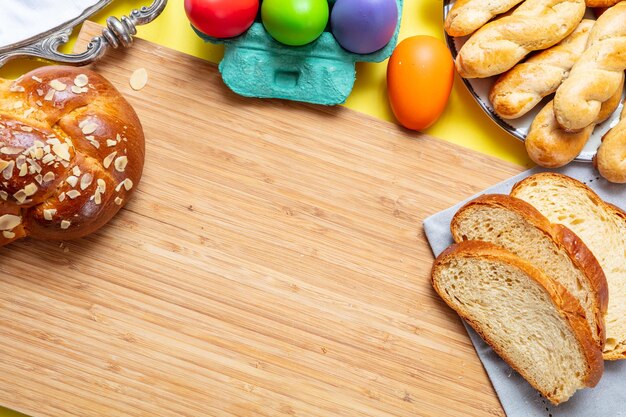 Foto huevos de pascua y tsoureki trenzan pan dulce de pascua griego en madera