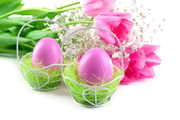 Huevos de Pascua y tulipanes aislados en blanco