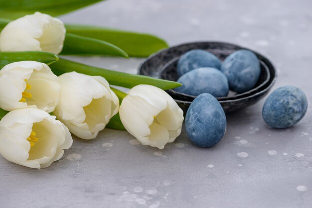 Huevos de pascua y tulipanes blancos