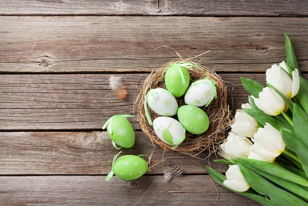 Huevos de pascua y tulipanes blancos