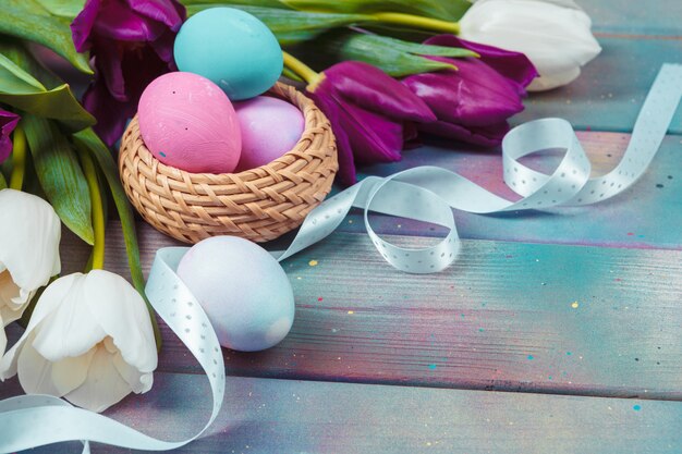 Huevos de Pascua con tulipanes en madera azul