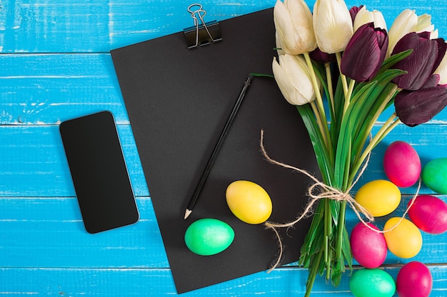 Huevos de pascua y tulipanes en tablones de madera azules