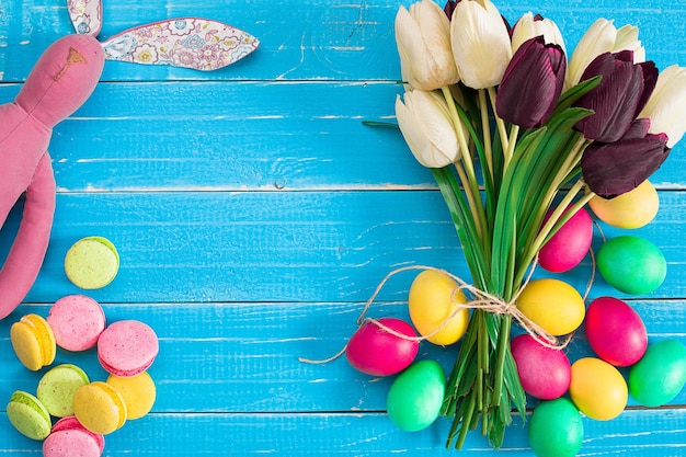 Huevos de pascua y tulipanes en tablones de madera azules