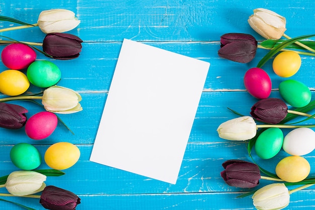 Huevos de pascua y tulipanes en tablones de madera azules