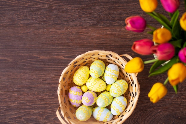 Huevos de pascua y tulipanes en tablones de madera.