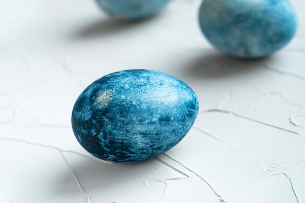 Huevos pintados de azul para las vacaciones de pascua. Tres huevos pintados sobre la mesa. Santa Pascua con pinturas naturales.