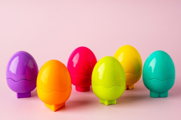 Huevos de plástico de juguete de colores sobre un fondo rosa. Juguete brillante fondo de Pascua. Concepto de Pascua Montessori. Huevos de Pascua para niños.
