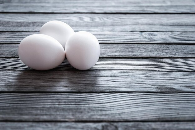 Huevos de pollo blancos en el espacio de copia de la mesa de madera