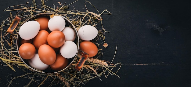 Huevos de pollo en una cacerola de metal Sobre un fondo de madera Vista superior Espacio de copia