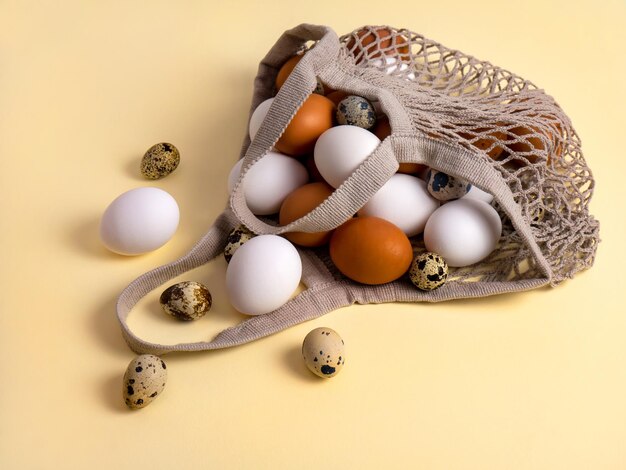 Huevos de pollo y codorniz en una bolsa de compras de malla Tarjeta de Pascua El concepto de cero desperdicio