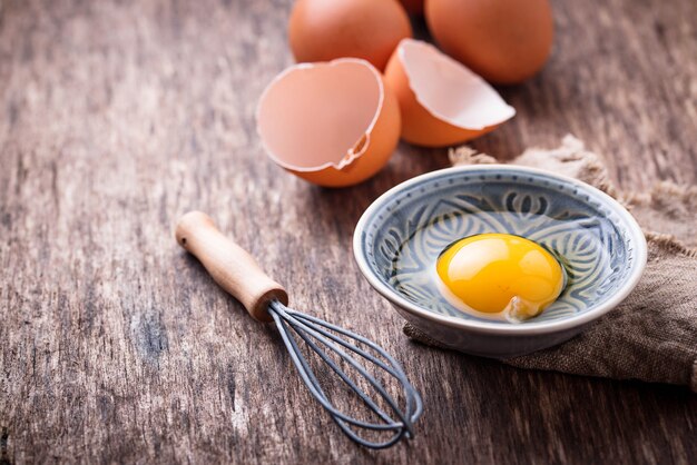 Huevos de pollo crudos y batidor