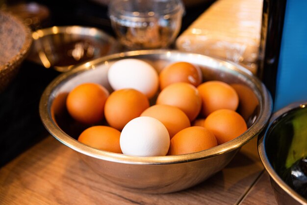 Huevos en un recipiente de metal sobre una mesa de madera en la cocina de un restaurante