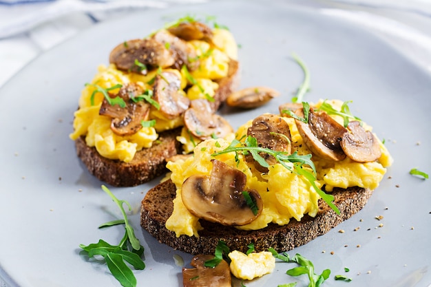 Huevos revueltos y champiñones fritos sobre pan