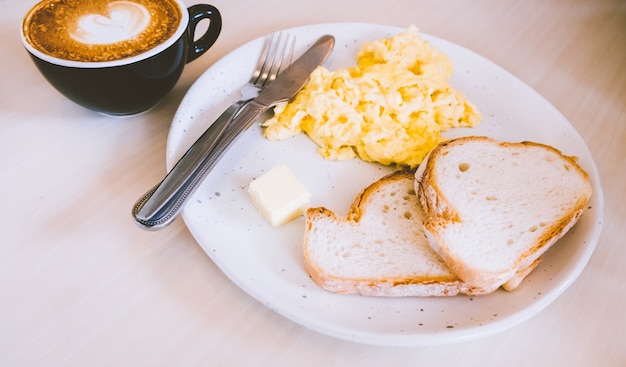 Huevos revueltos de mascarpone con tostadas de ajo con café con leche caliente