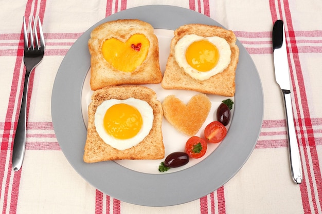 Huevos revueltos con pan en un plato en una servilleta de color