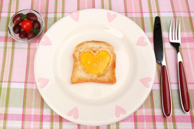 Huevos revueltos con pan en un plato en una servilleta de color