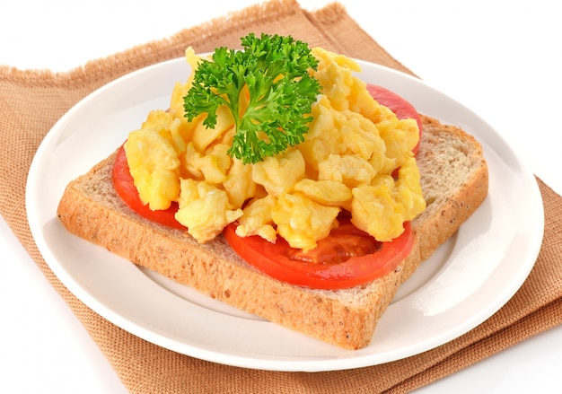 Huevos revueltos con perejil, tomate y pan.